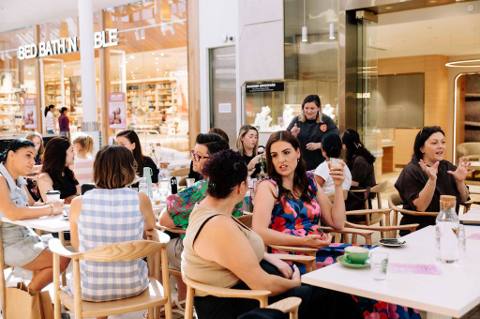 A full room of women at cafe tables during a Wanna Grab a Coffee morning