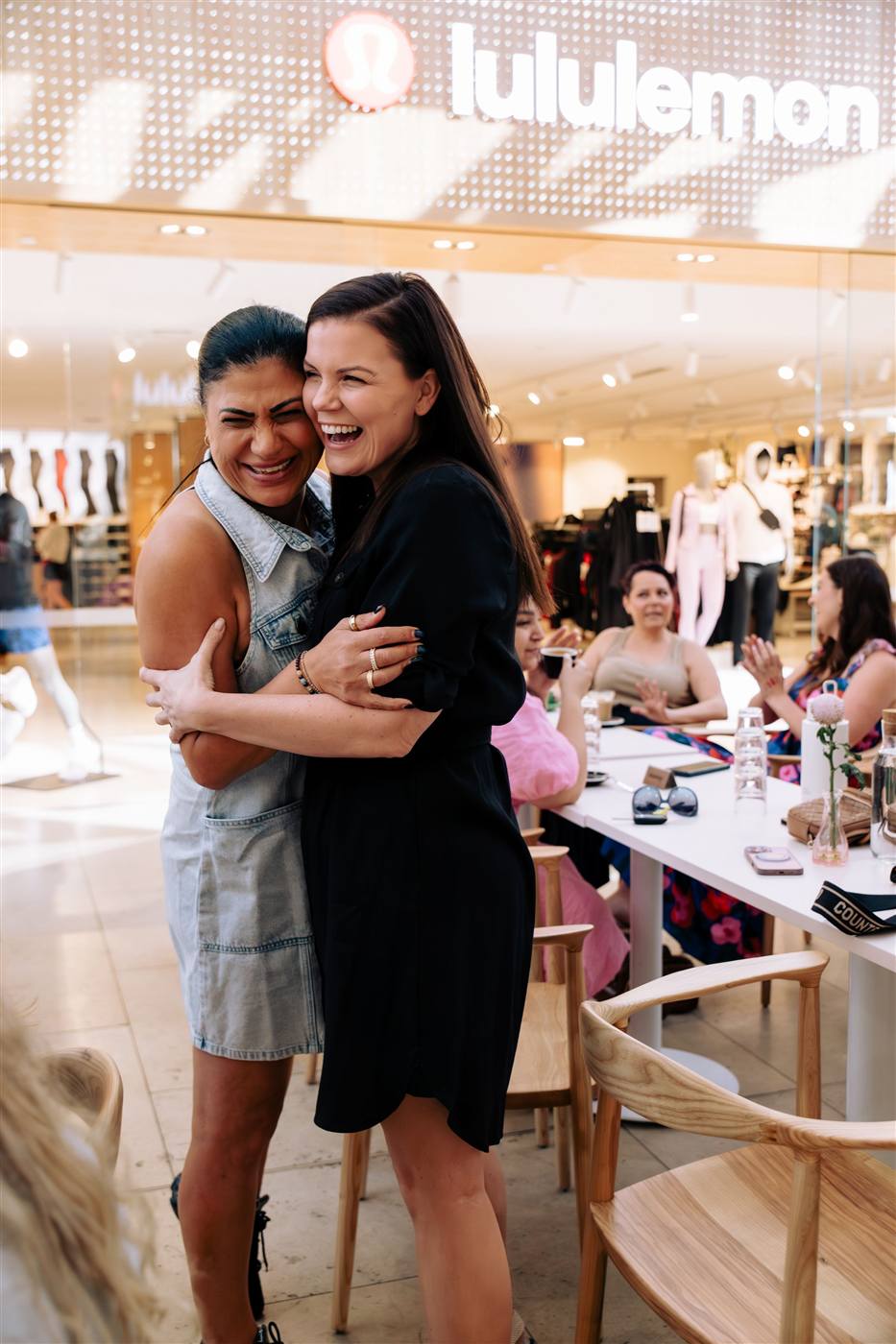 Elba and Niamh greeting each other with a huge hug at a cafe