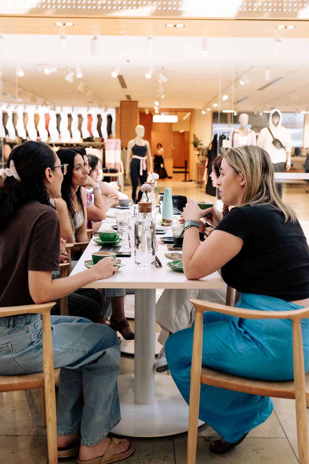Women working and talking down a long table at a Village Circle in Adelaide