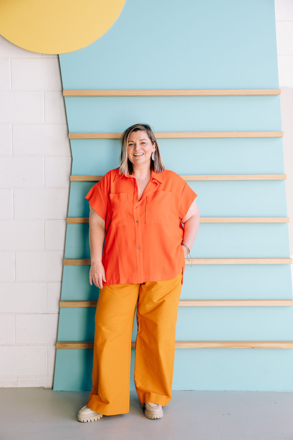 Sandra, smiling, in front of a blue wall