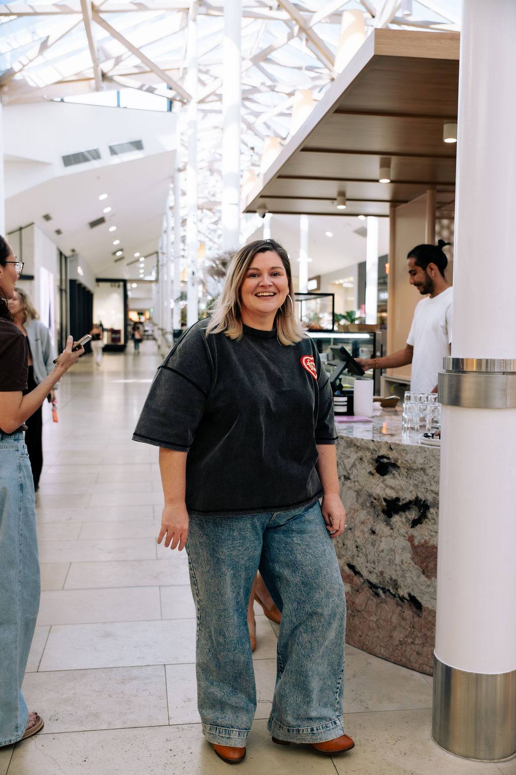 Sandra laughing in a cafe, hands in pockets, completely at home
